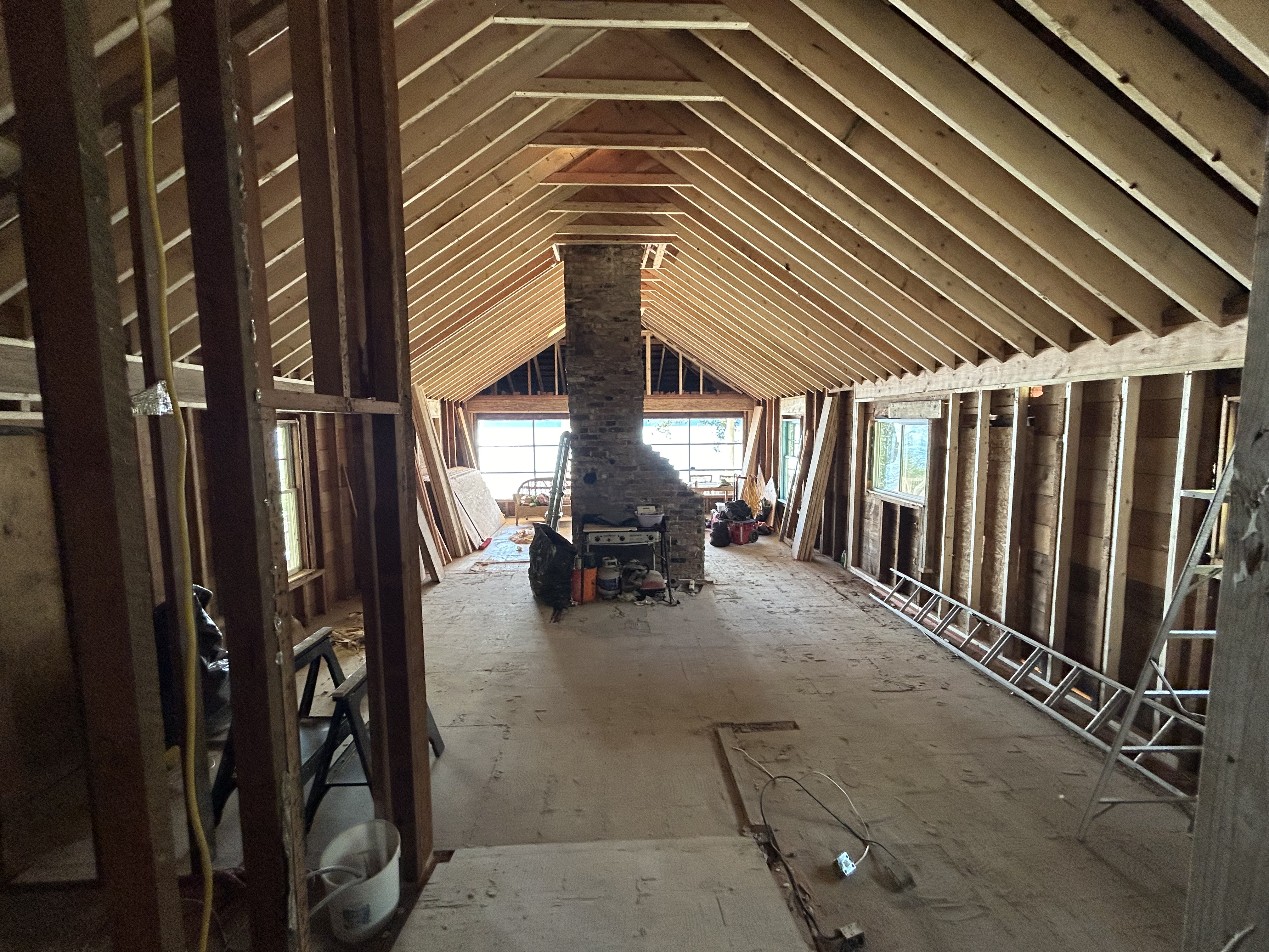 Gambier Island cabin renovation — vaulted ceiling framing and brick chimney, interior in progress